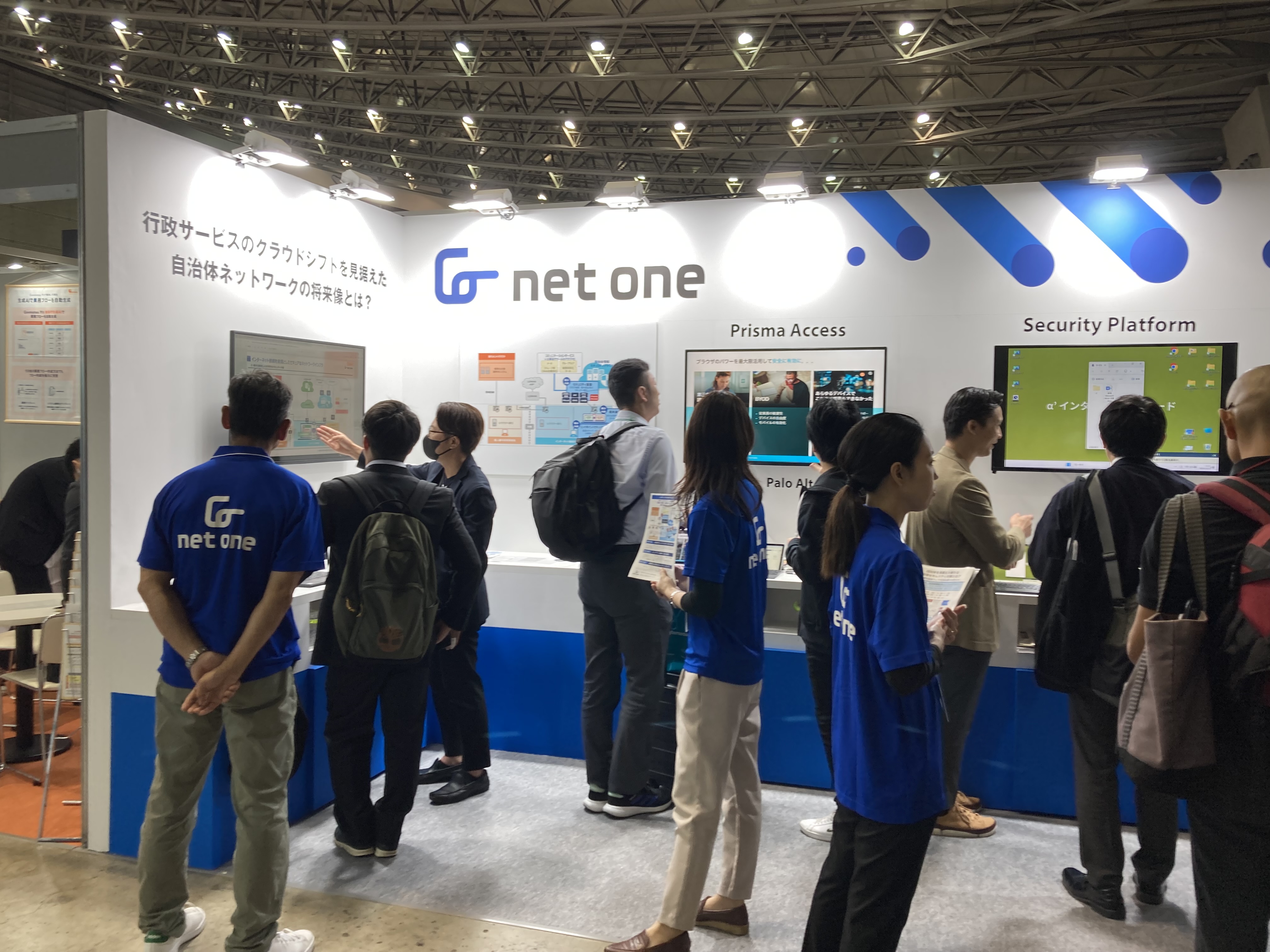 展示ブースにて当社社員と来場者が話している写真。
